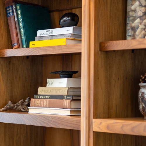 All the comforts of luxury living a bookshelf with books and trinkets